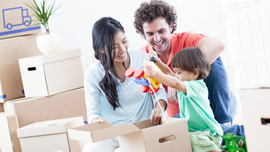 couple with one child unpacking boxes after moving into new home